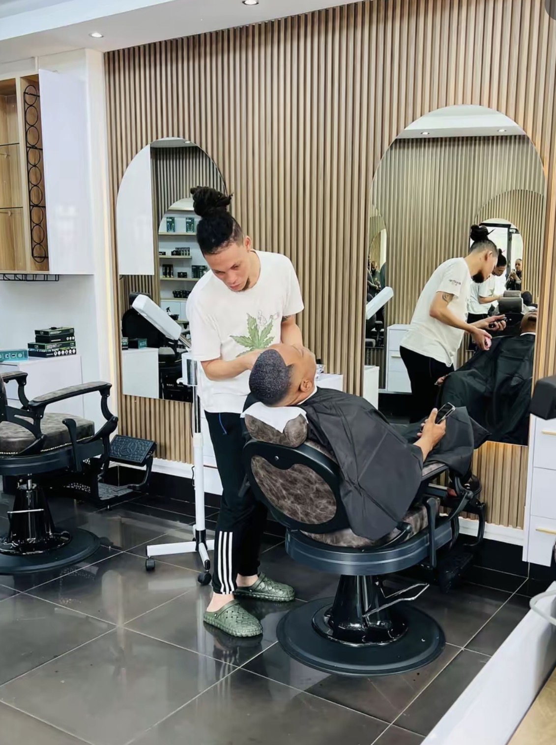 Barber working beneath the arched mirror gallery